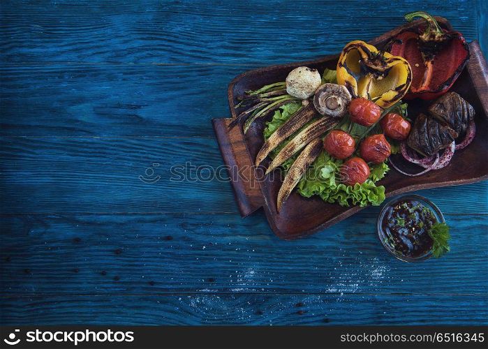 Grilled vegetable on a blue wooden background. Grilled vegetable at plate. Grilled vegetable at plate