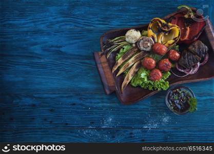 Grilled vegetable on a blue wooden background. Grilled vegetable at plate. Grilled vegetable at plate
