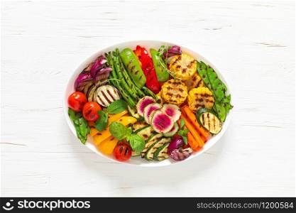 Grilled vegetables on a white plate, top view