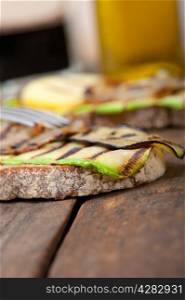 grilled vegetables on rustic bread over wood table