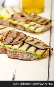 grilled vegetables on rustic bread over wood table