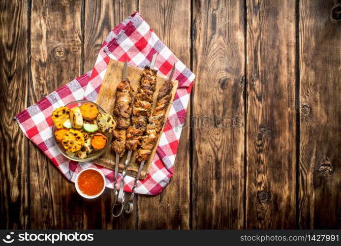 Grilled vegetables with a fragrant Shish kebab from mutton.On wooden background.. Grilled vegetables with a fragrant Shish kebab from mutton.