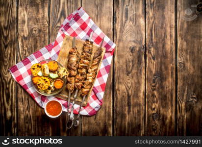 Grilled vegetables with a fragrant Shish kebab from mutton.On wooden background.. Grilled vegetables with a fragrant Shish kebab from mutton.