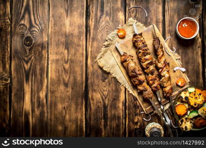 Grilled vegetables with a fragrant Shish kebab from mutton.On wooden background.. Grilled vegetables with a fragrant Shish kebab from mutton.