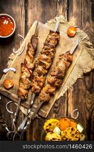 Grilled vegetables with a fragrant Shish kebab from mutton.On wooden background.. Grilled vegetables with a fragrant Shish kebab from mutton.