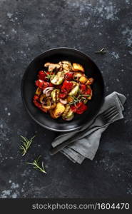 Grilled vegetables with mushrooms in a plate on a dark background