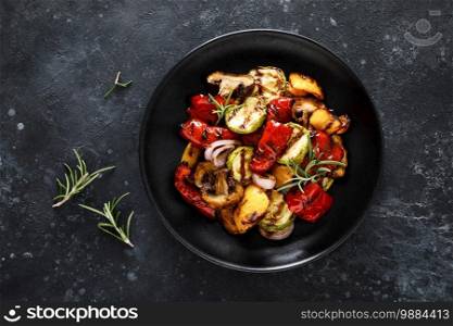 Grilled vegetables with mushrooms in a plate on a dark background