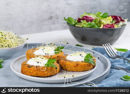 Grilled veggie burgers with chickpeas and vegetables and parsley leaves on ceramic plates.