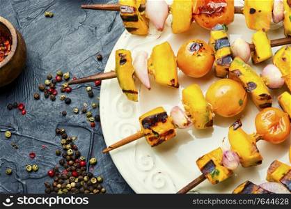 Grilled veggie skewers with pumpkin,cherry tomatoes and onions. Grilled pumpkin on a skewer