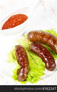 grilled venison sausage closeup with lettuce and sauce