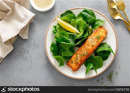 Grillet salmon and fresh spinach salad dressed with lemon
