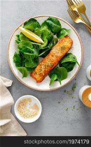 Grillet salmon and fresh spinach salad dressed with lemon