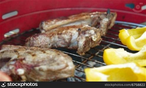 Grilling at summer weekend. Fresh steaks and vegetables preparing on grill