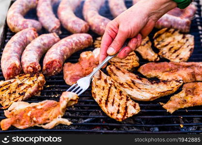 Grilling sausages and pork chops on barbecue grill. BBQ in the garden