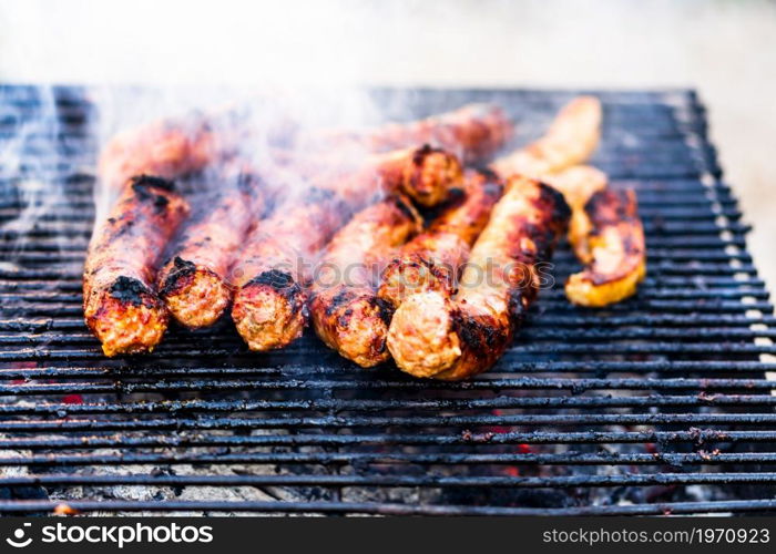 Grilling sausages on barbecue grill. Delicious sausages on charcoal grill