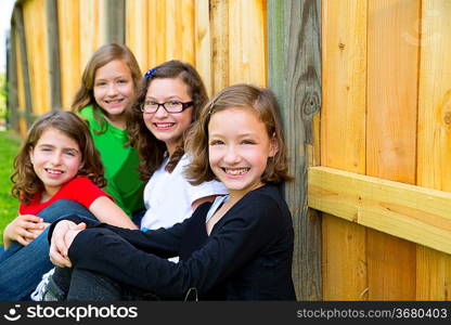 Grils group in a row smiling in a wooden fence outdoor