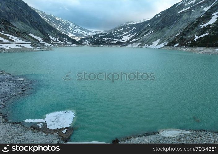Grimsel Pass summer cloudy landscape with lake (Switzerland, Bernese Alps).
