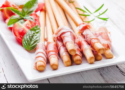 Grissini with prosciutto crudo - antipasto - italian appetizer