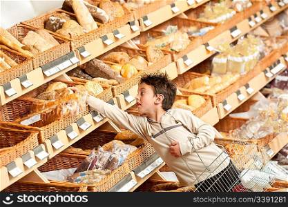 Grocery store shopping - Boy buying bread and holding shopping basket