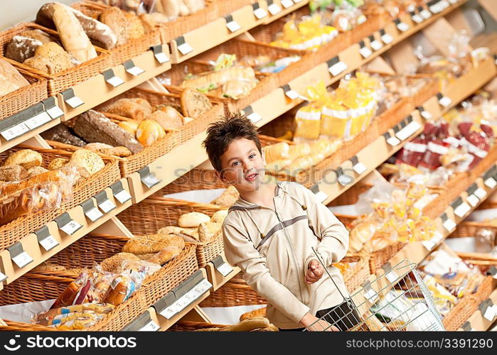 Grocery store shopping - Little boy in a supermarket holding shopping basket