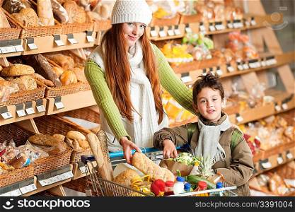 Grocery store shopping - Long red hair woman with little boy in a supermarket