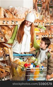 Grocery store shopping - Red hair woman with child choosing bread