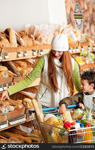 Grocery store shopping - Red hair woman with little boy in a supermarket