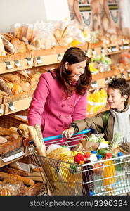 Grocery store shopping - Woman with child in winter outfit in a supermarket