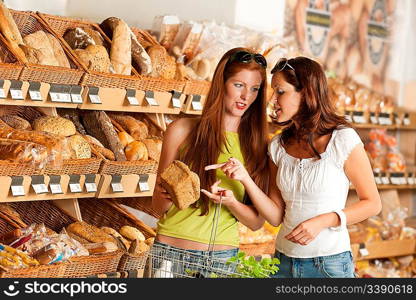 Grocery store: Two women choosing bread at bakery