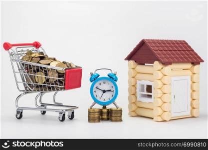 Grocery trolley filled with coins, desk clock and children&rsquo;s house