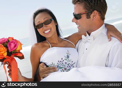 Groom Carrying Bride on Beach