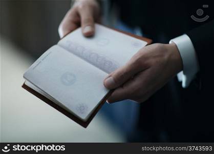 Groom holding an empty passport without a stamp before the wedding