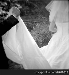 Groom holding the veil of a bride