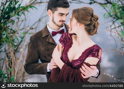 groom in a brown and bride in burgundy in the mountains Carpathians