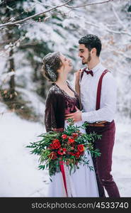 groom in a brown and bride in burgundy in the mountains Carpathians