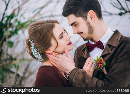 groom in a brown and bride in burgundy in the mountains Carpathians