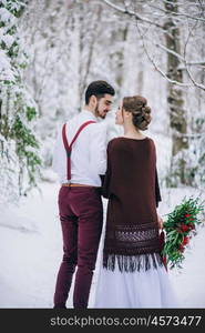 groom in a brown and bride in burgundy in the mountains Carpathians