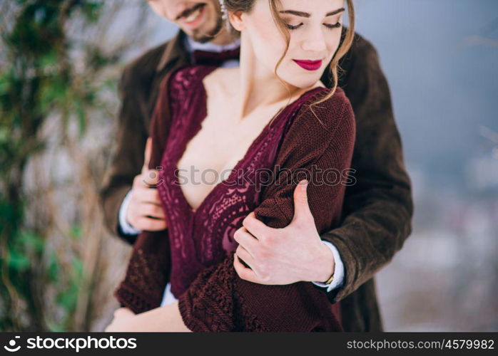 groom in a brown and bride in burgundy in the mountains Carpathians