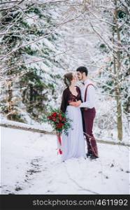 groom in a brown and bride in burgundy in the mountains Carpathians