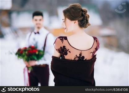 groom in a brown and bride in burgundy in the mountains Carpathians