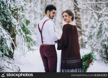 groom in a brown and bride in burgundy in the mountains Carpathians