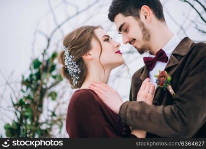 groom in a brown and bride in burgundy in the mountains Carpathians