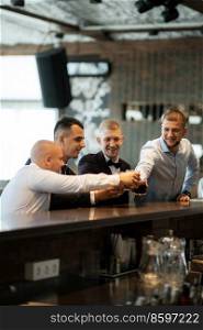 groom in a brown suit and his friends at the bar