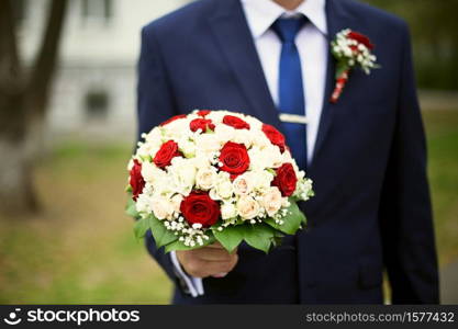 Groom with bouquet of roses