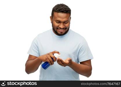 grooming and people concept - happy african american man applying shaving foam to his hand over white background. happy african man applying shaving foam to hand