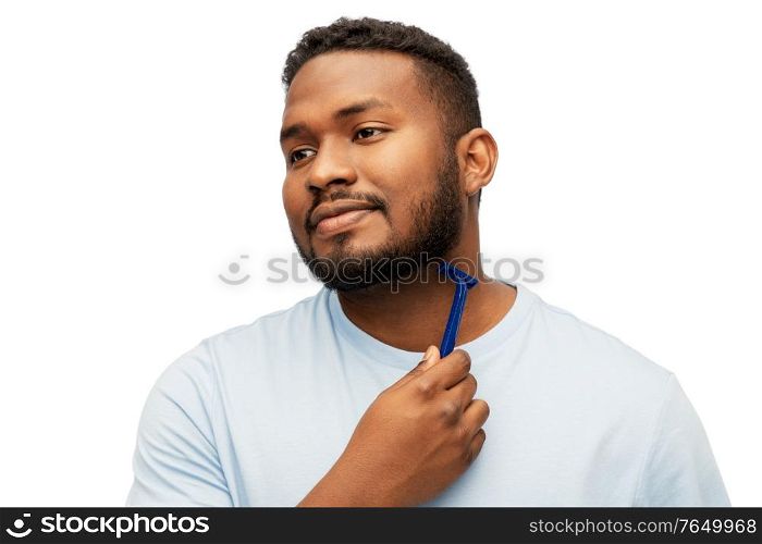 grooming and people concept - young african american man shaving beard with manual razor blade over white background. african man shaving beard with razor blade