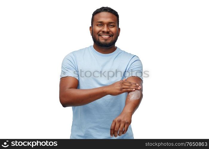 grooming, bodycare and people concept - happy african american man applying moisturizer to his hand over white background. happy african man applying moisturizer to his hand