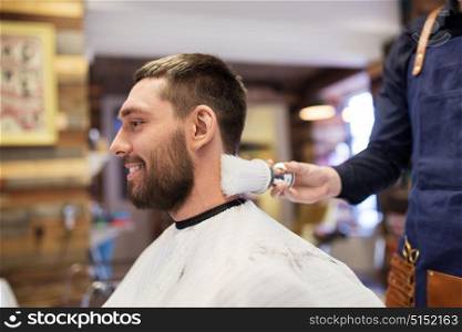 grooming, hairdressing and people concept - man and barber cleaning neck with brush at barbershop. barber with brush cleaning male neck at barbershop