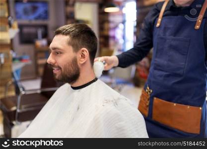 grooming, hairdressing and people concept - man and barber cleaning neck with brush at barbershop. barber with brush cleaning male neck at barbershop