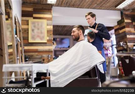grooming, hairstyle and people concept - man and hairstylist or hairdresser with mirror at barbershop. man and hairdresser with mirror at barbershop